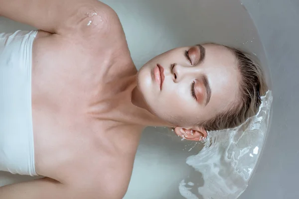 Vue de dessus de femme sexy avec les yeux fermés dans la baignoire — Photo de stock