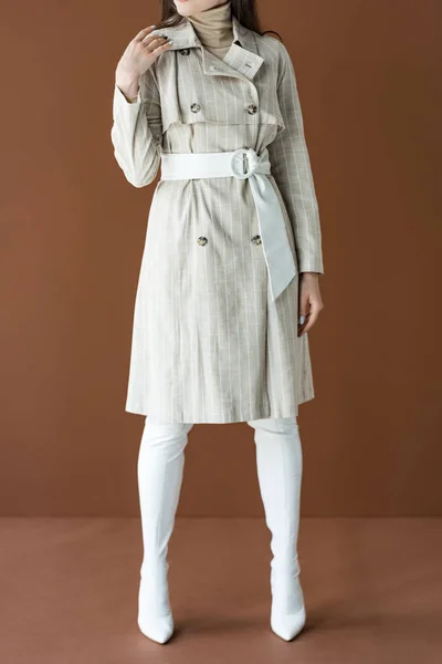 Vista cortada da mulher na moda em casaco de trincheira isolado em marrom — Fotografia de Stock