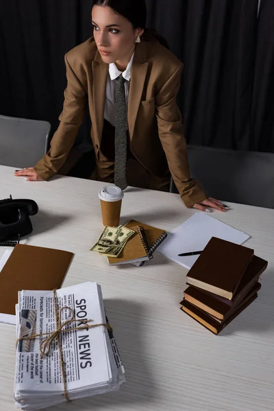 Blick aus der Vogelperspektive auf erfolgreiche Geschäftsfrau, die im Büro hinter einem Tisch steht und wegschaut — Stockfoto