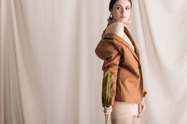 Femme à la mode debout sur fond de rideau, regardant loin — Photo de stock