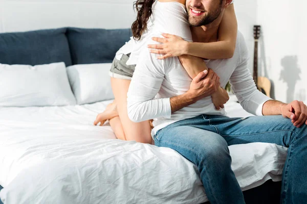 Abgeschnittene Ansicht eines jungen Paares, das sich morgens im Bett umarmt — Stockfoto