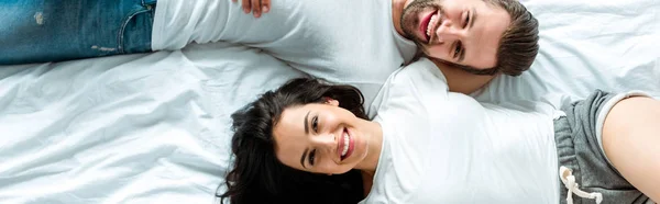 Vista superior de pareja feliz acostados juntos en la cama, plano panorámico - foto de stock