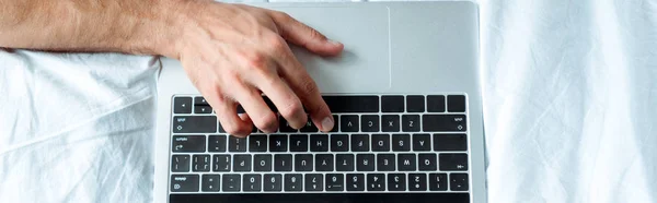 Plano panorámico del hombre escribiendo en el teclado del ordenador portátil, editorial ilustrativa - foto de stock