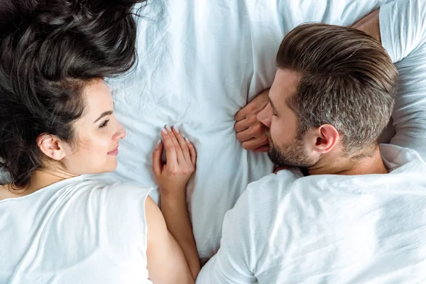 Vista superior da mulher olhando para o namorado adormecido na cama — Fotografia de Stock