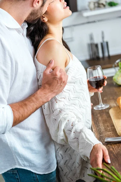 Homem apaixonado abraçando e beijando mulher na cozinha — Fotografia de Stock