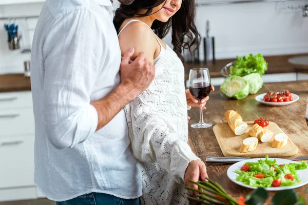 Vista parcial de hombre apasionado tocando mujer en la cocina - foto de stock