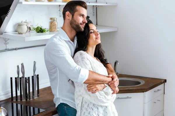 Homem gentilmente abraçando mulher feliz em casa — Fotografia de Stock