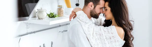Beau couple embrassant doucement avec les yeux fermés à la cuisine, vue panoramique — Photo de stock