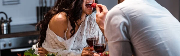 Vista cortada de homem alimentando mulher com morango, tiro panorâmico — Fotografia de Stock