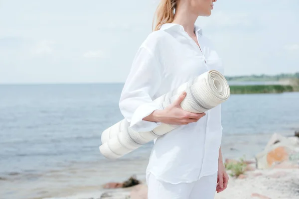 Cropped view of young blonde woman holding yoga mat — Stock Photo