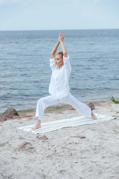 Hermosa chica practicando yoga y de pie con las manos de oración - foto de stock