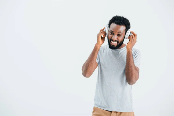 Cheerful african american man listening music with headphones, isolated on grey — Stock Photo