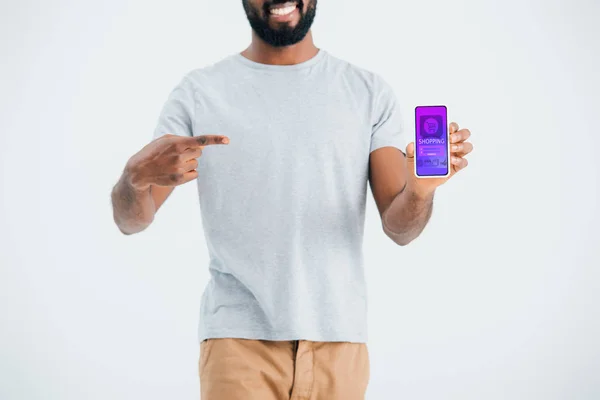 KYIV, UKRAINE - 17 MAI 2019 : Vue recadrée d'un homme afro-américain pointant du doigt un smartphone avec une application shopping, isolé sur gris — Photo de stock