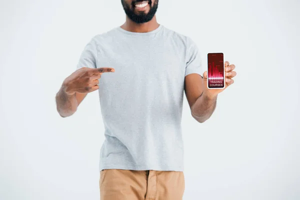 Visão recortada do homem afro-americano apontando para smartphone com aplicativo de cursos comerciais, isolado em cinza — Fotografia de Stock