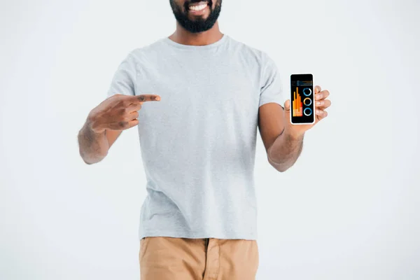 Cropped view of african american man pointing at smartphone with infographic, isolated on grey — Stock Photo