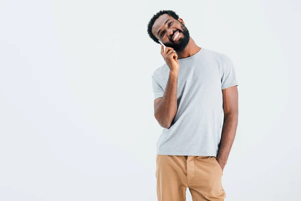 Щасливий афроамериканський чоловік розмовляє на смартфоні, ізольований на сірому — стокове фото
