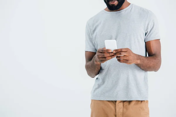 Обрезанный вид на африканского американца с помощью смартфона, изолированный на сером — стоковое фото