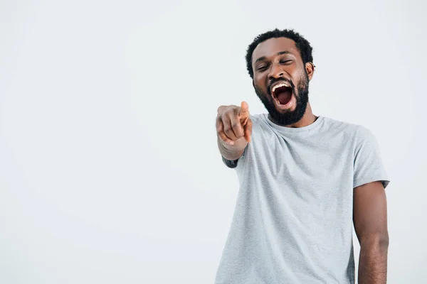 Hombre afroamericano riendo y señalando aislado en gris - foto de stock