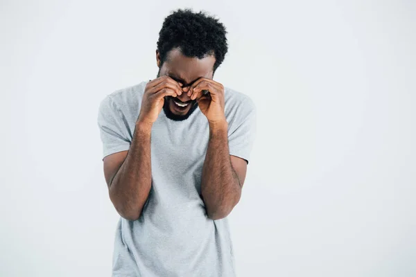 Lonely african american man in grey t-shirt crying isolated on grey — Stock Photo