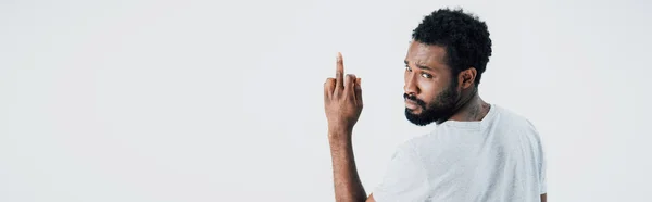 Hombre afroamericano enojado en camiseta gris que muestra el dedo medio aislado en gris - foto de stock