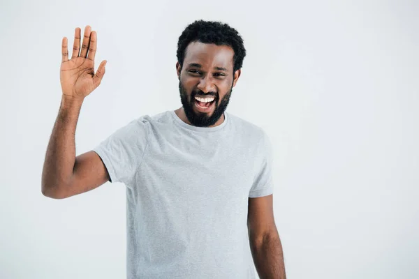 Веселий афроамериканський чоловік у сірій футболці махає ізольовано на сірому — стокове фото