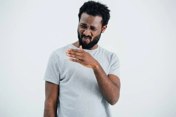 Confused upset african american man in grey t-shirt isolated on grey — Stock Photo