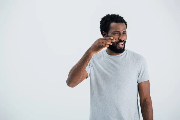 Triste africano americano hombre en gris camiseta gesto aislado en gris - foto de stock