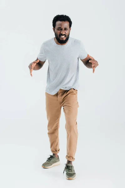 Homme afro-américain agressif en t-shirt gris posant isolé sur gris — Photo de stock