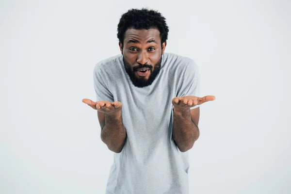 Emotional african american man in grey t-shirt gesturing isolated on grey — Stock Photo