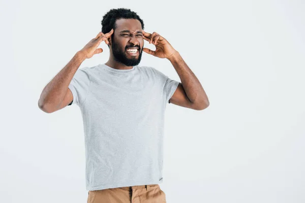 Homme afro-américain en colère ayant mal à la tête isolé sur gris — Photo de stock