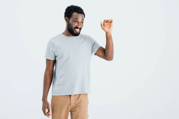 African american man in grey t-shirt waving isolated on grey — Stock Photo