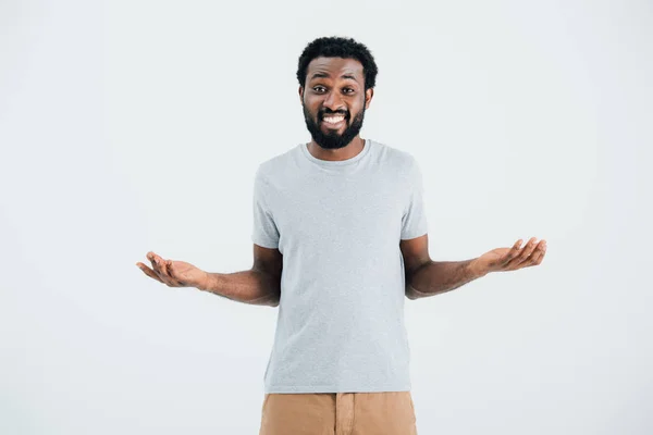 Homme afro-américain en t-shirt gris avec geste haussant les épaules isolé sur gris — Photo de stock