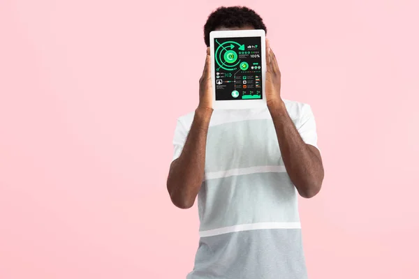 Афроамериканський чоловік, що показує цифровий планшет з інфографікою, ізольований на рожевому — стокове фото