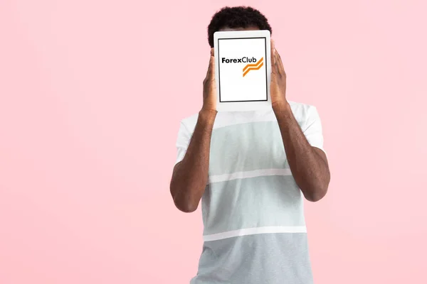 Kyiv, ukraine - 17. Mai 2019: afrikanisch-amerikanischer Mann schreit und zeigt digitales Tablet mit Forex Club App, isoliert auf rosa — Stockfoto