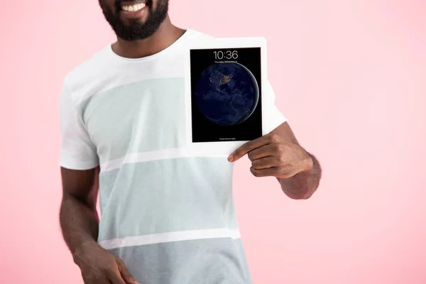 KYIV, UKRAINE - MAY 17, 2019: cropped view of african american man showing digital tablet, isolated on pink — Stock Photo