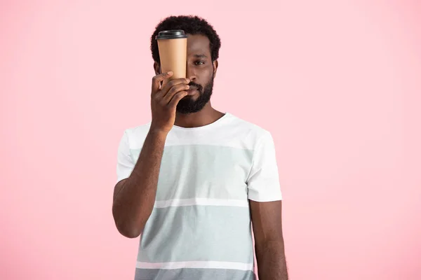 Sonolento afro-americano segurando café para ir, isolado em rosa — Stock Photo