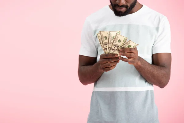 Vista cortada do homem americano africano que prende notas de dólares, isolado no rosa — Fotografia de Stock
