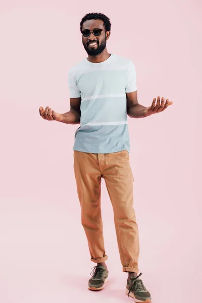 Sorridente afro-americano de homem de óculos de sol gestual, isolado em rosa — Fotografia de Stock