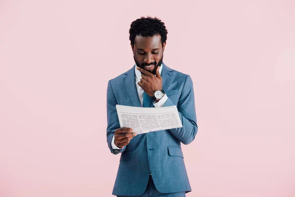 Glücklich afrikanisch-amerikanischer Geschäftsmann liest Zeitung isoliert auf rosa — Stockfoto