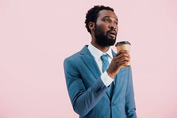 Müde afrikanisch-amerikanische Geschäftsmann mit Coffee to go, isoliert auf rosa — Stockfoto