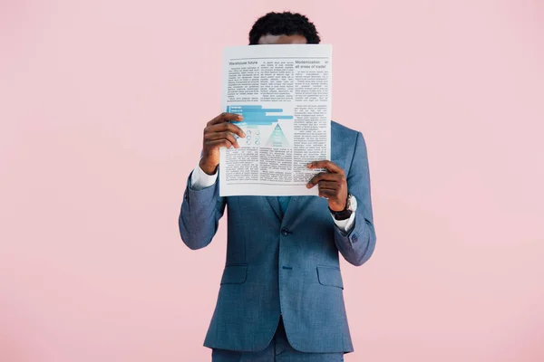African american businessman reading newspaper isolated on pink — Stock Photo