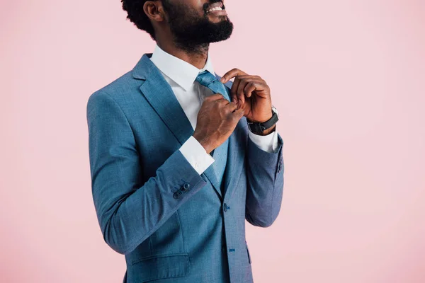 Vista recortada de hombre de negocios afroamericano en traje y corbata, aislado en rosa - foto de stock