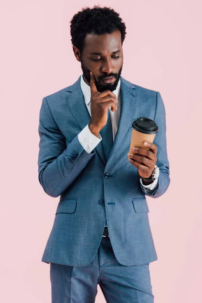 Pensivo empresário afro-americano segurando café para ir, isolado em rosa — Fotografia de Stock