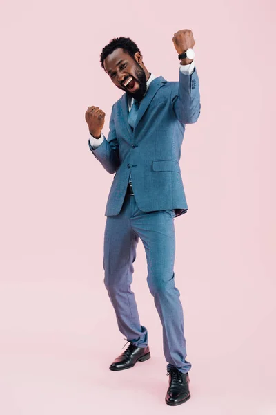 Excited successful african american businessman in suit, isolated on pink — Stock Photo