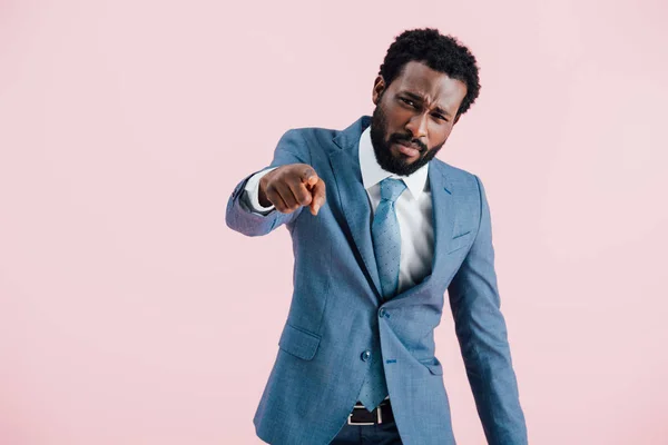 Wütender afrikanisch-amerikanischer Geschäftsmann im Anzug zeigt vereinzelt auf rosa — Stockfoto