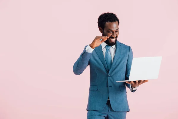 Happy african american businessman having video chat on laptop isolated on pink — Stock Photo