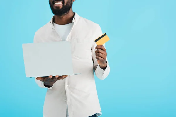 Vue recadrée de l'homme afro-américain faisant des achats en ligne avec carte de crédit et ordinateur portable isolé sur bleu — Photo de stock