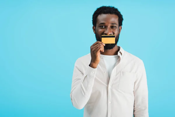 Веселый африканский американец показывает кредитную карту изолированы на синий — стоковое фото