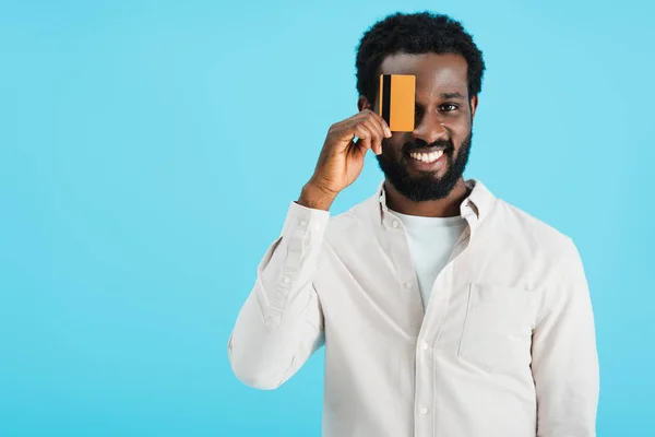 Heureux homme afro-américain montrant carte de crédit isolé sur bleu — Photo de stock
