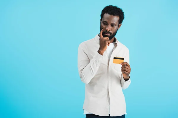 Uomo afroamericano premuroso mostrando carta di credito isolata sul blu — Foto stock